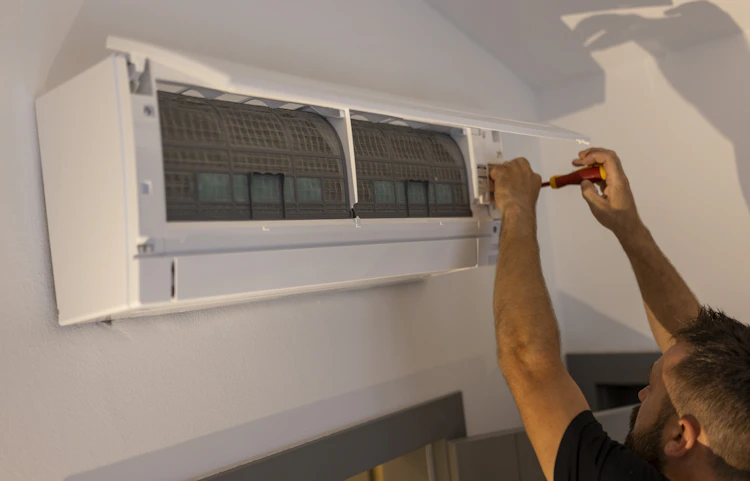Technicien en intervention sur une unité intérieure d'une climatisation qui fait sauter le disjoncteur