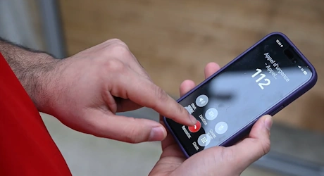 Mains composant le numéro d'urgence 112 sur un smartphone