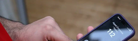 Mains composant le numéro d'urgence 112 sur un smartphone