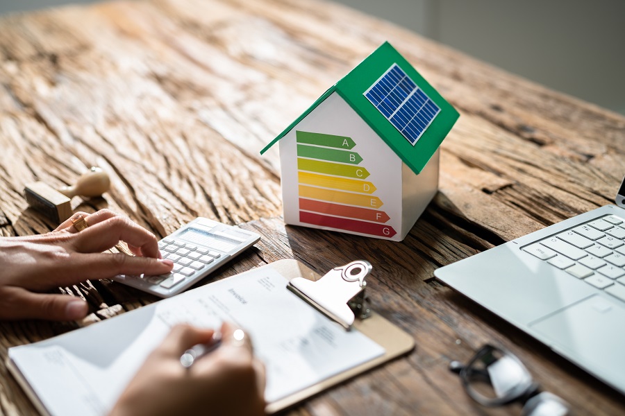 Maquette de maison avec étiquette énergétique colorée sur un bureau
