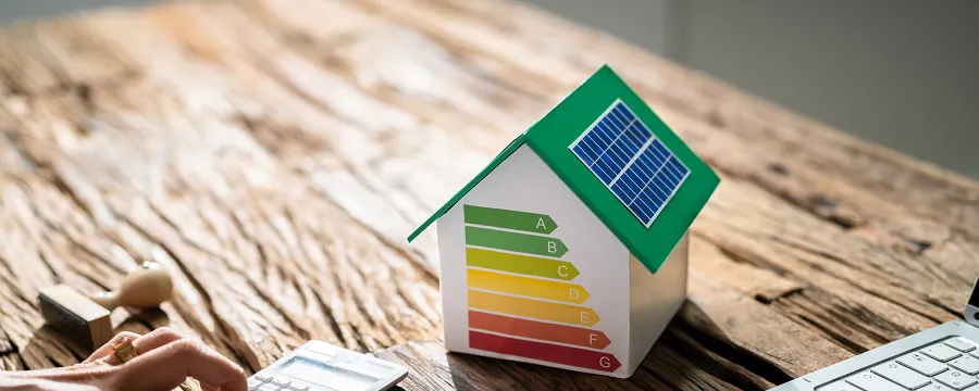 Maquette de maison avec étiquette énergétique colorée sur un bureau