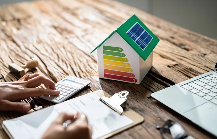 Maquette de maison avec étiquette énergétique colorée sur un bureau