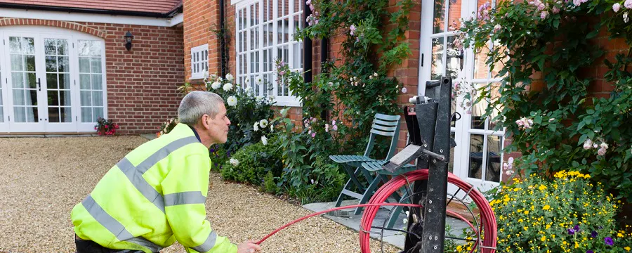 Technicien en gilet jaune inspectant une canalisation avec une caméra