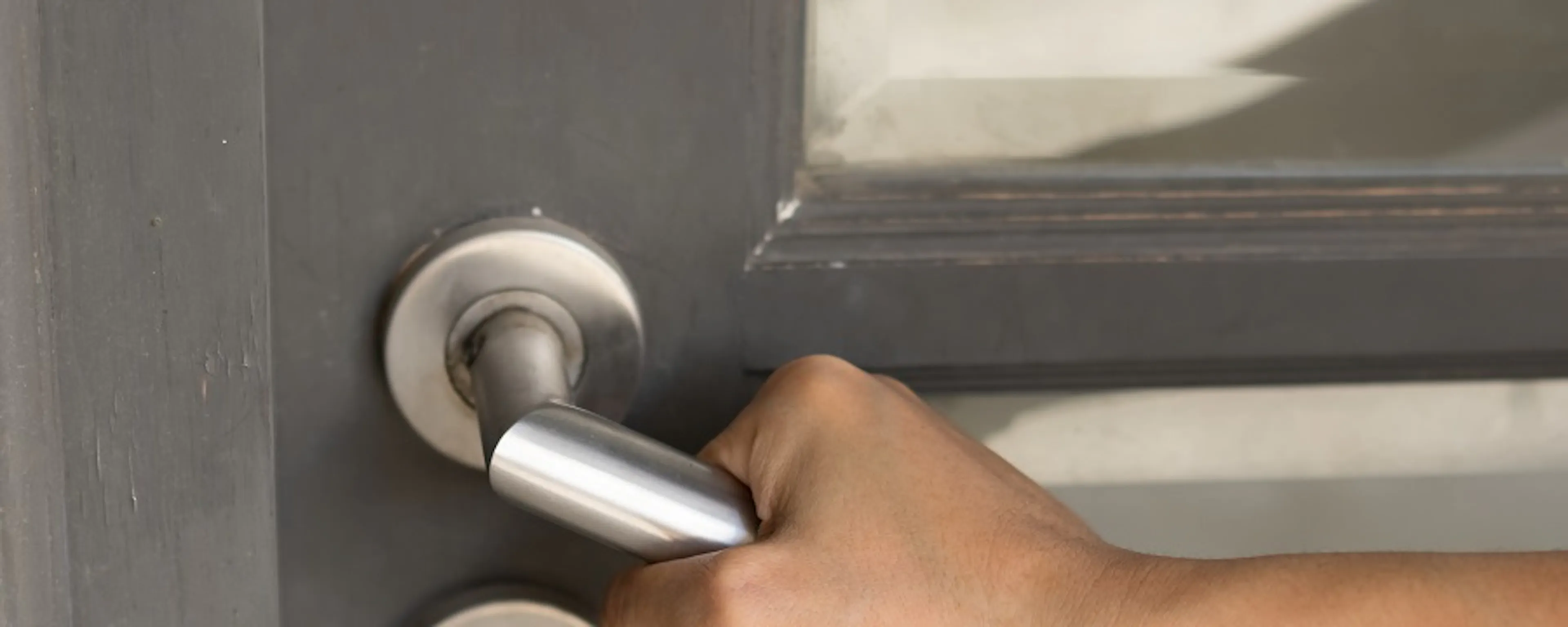 Main saisissant une poignée de porte en métal gris