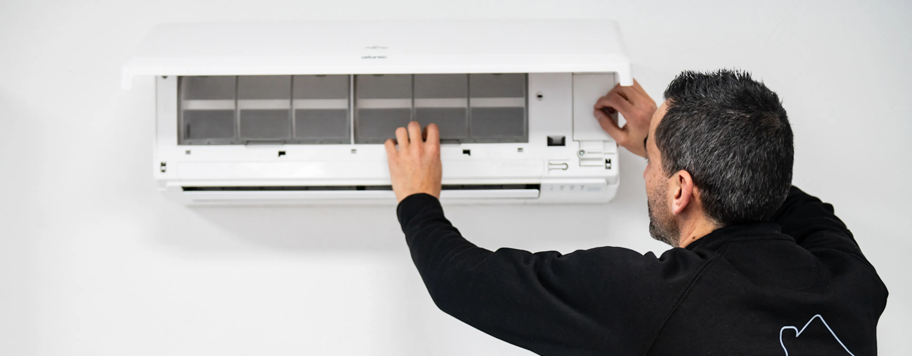 Technicien HomeServe finissant l'installation d'une climatisation réversible dans une maison près de Nice