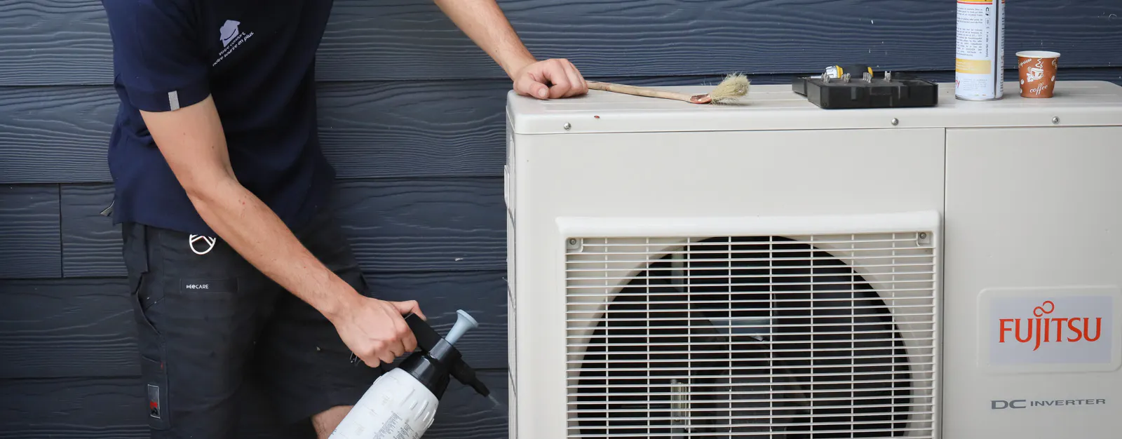 Un technicien de maintenance climatisation intervenant sur l'unité extérieure dans le cadre d'un contrat d'entretien