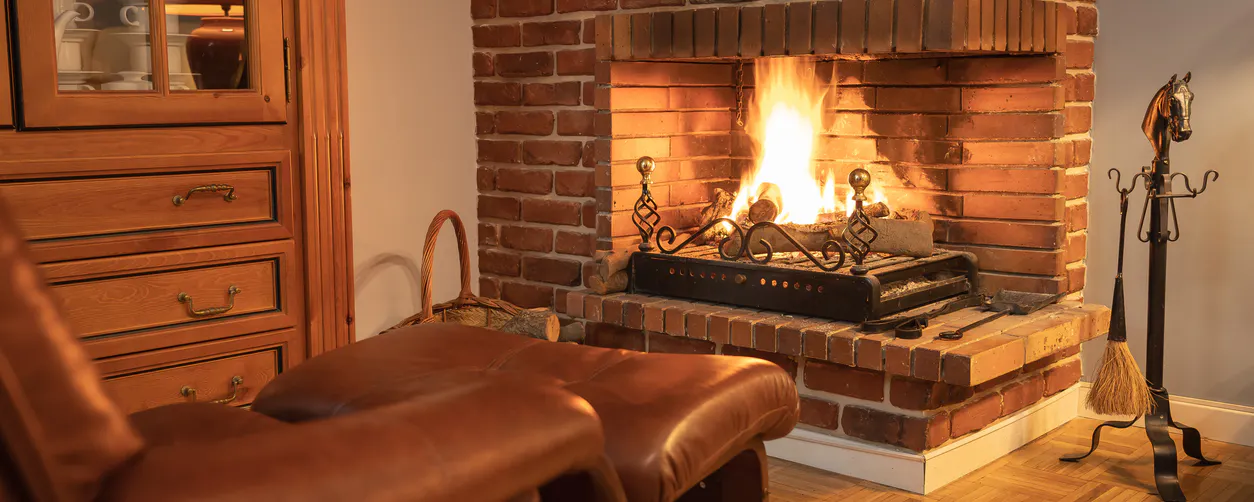 Une cheminée ancienne ouverte sur un salon vintage : son rendement est bas (pas plus de 15%). Est-il possible d'installer un poêle à bois dans le foyer ?