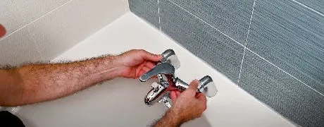 Technicien installant un robinet de baignoire mural