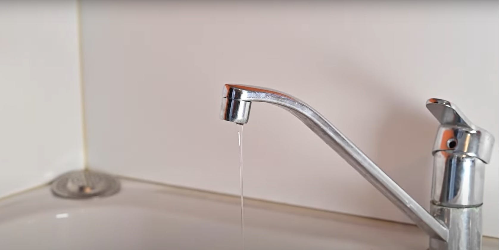 Robinet de cuisine chromé qui goutte au-dessus d'un évier