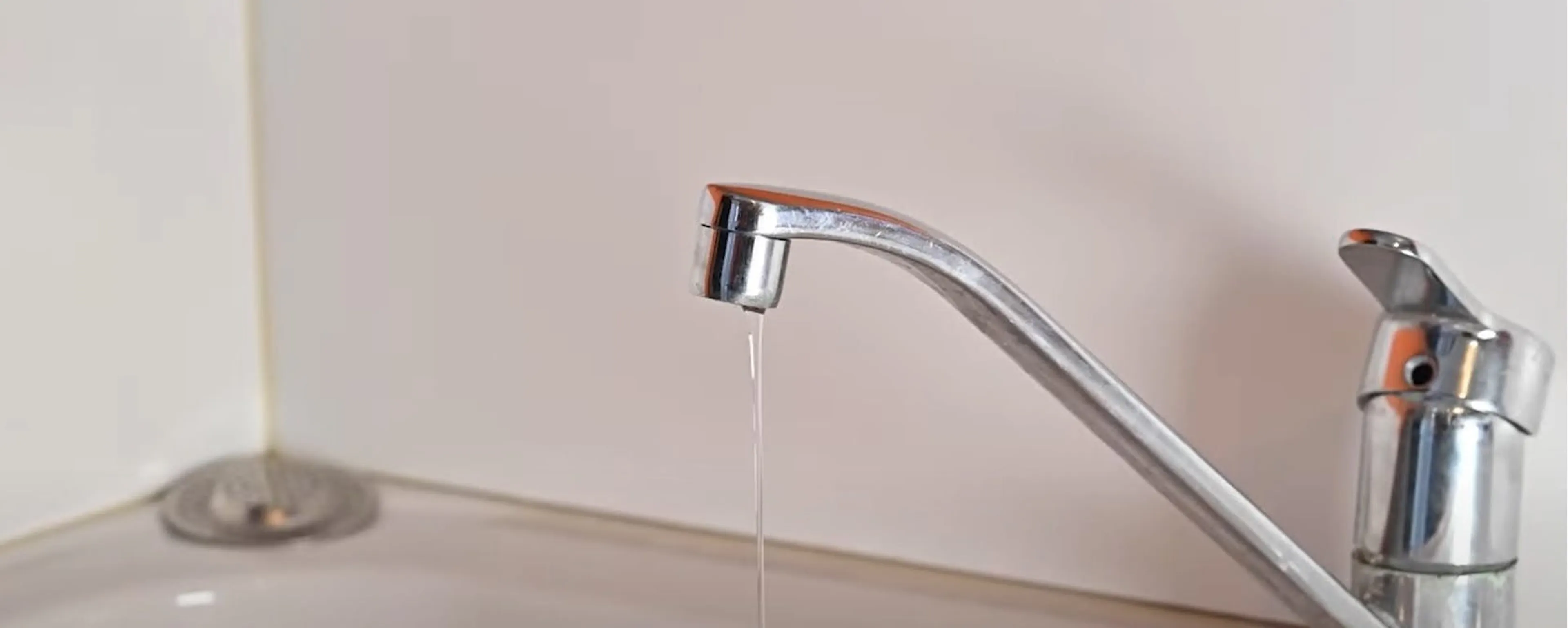 Robinet mitigeur chromé à changer de cuisine qui goutte au-dessus d'un évier