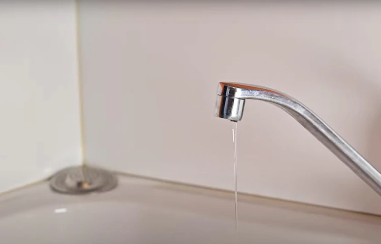 Robinet de cuisine chromé qui goutte au-dessus d'un évier