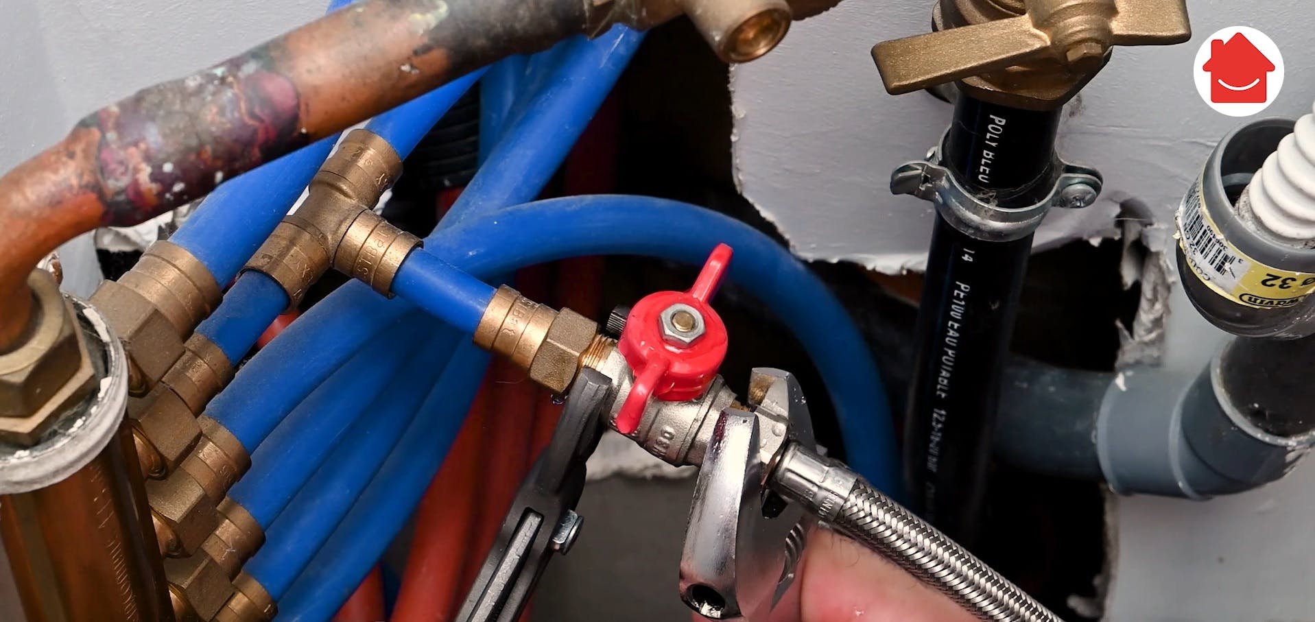 Réseau de tuyaux bleus et cuivrés avec vanne rouge en plomberie