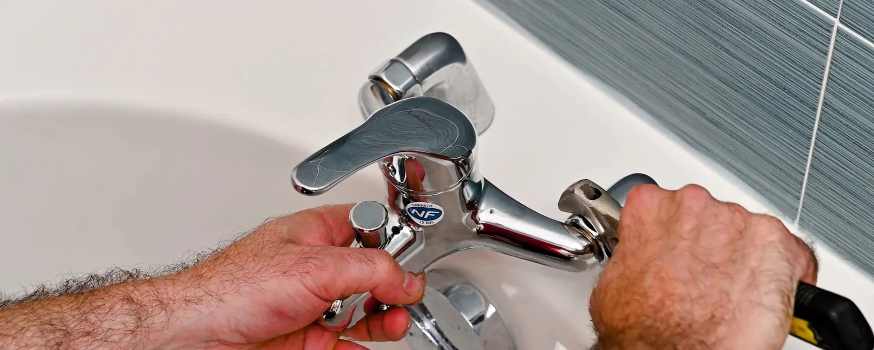 Plombier changeant un robinet de baignoire défectueux