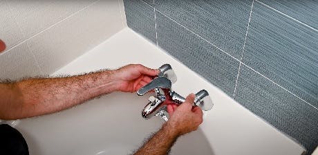 Technicien installant un robinet de baignoire mural