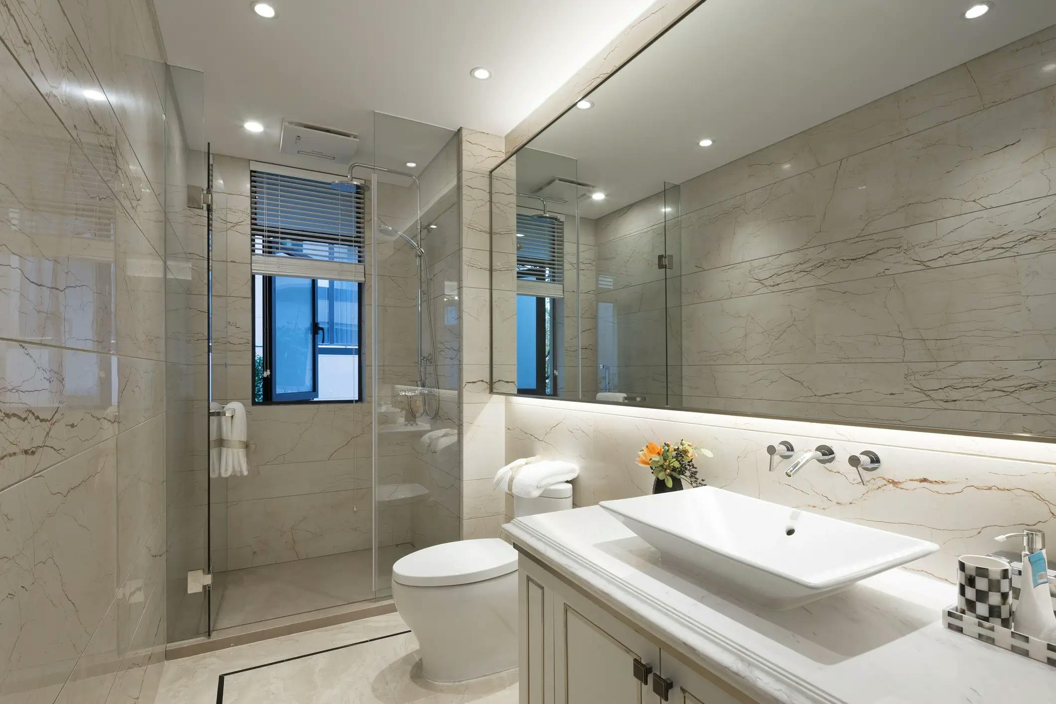 Salle de bain moderne blanche avec douche vitrée et grand miroir