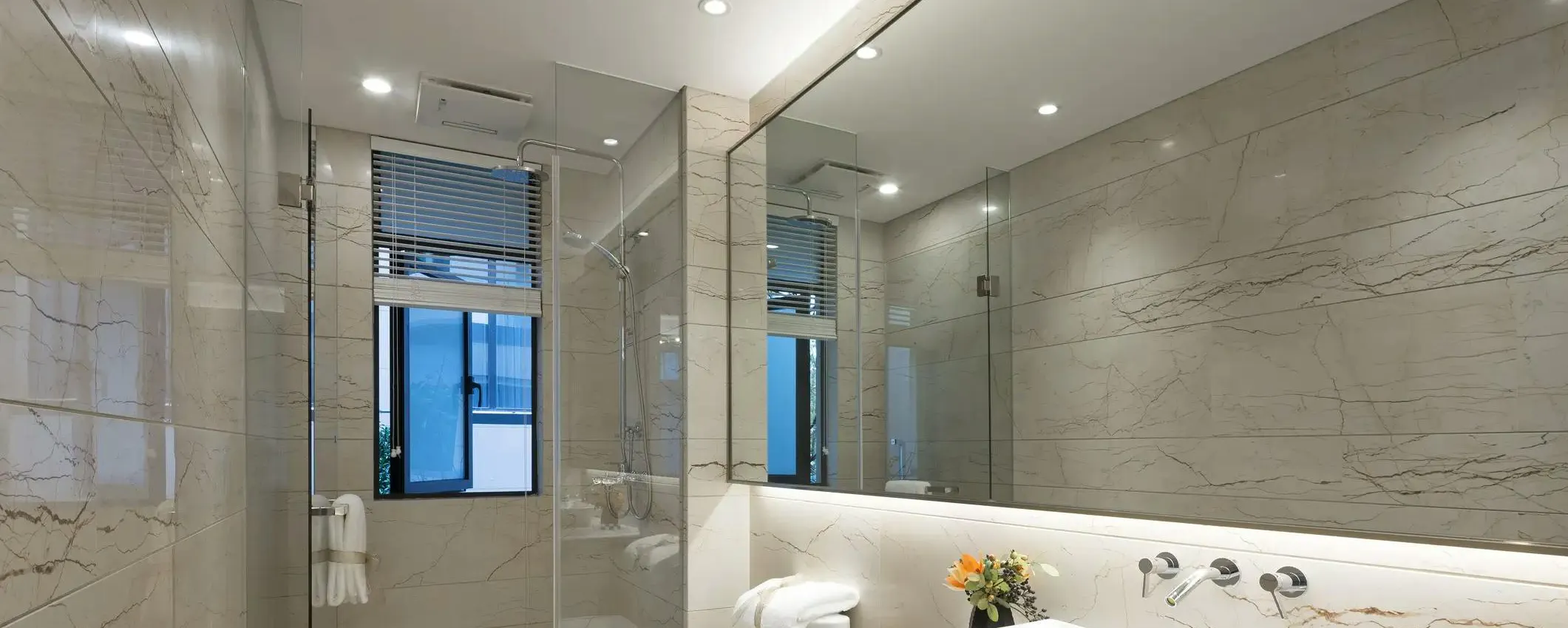 Salle de bain moderne avec douche vitrée et au plafond des spots installés