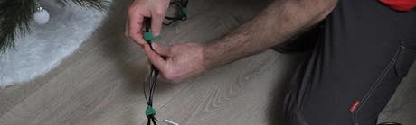 Personne branchant des guirlandes lumineuses au sol