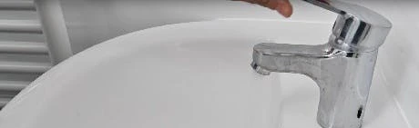 Robinet de lavabo ouvert avec filet d'eau qui coule