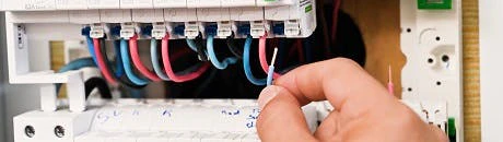 Main manipulant des disjoncteurs dans un tableau électrique Schneider