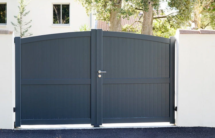 Portail double anthracite en aluminium devant une maison blanche