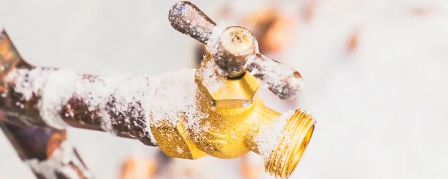 Robinet extérieur en laiton recouvert de givre et neige — comment le protéger du gel