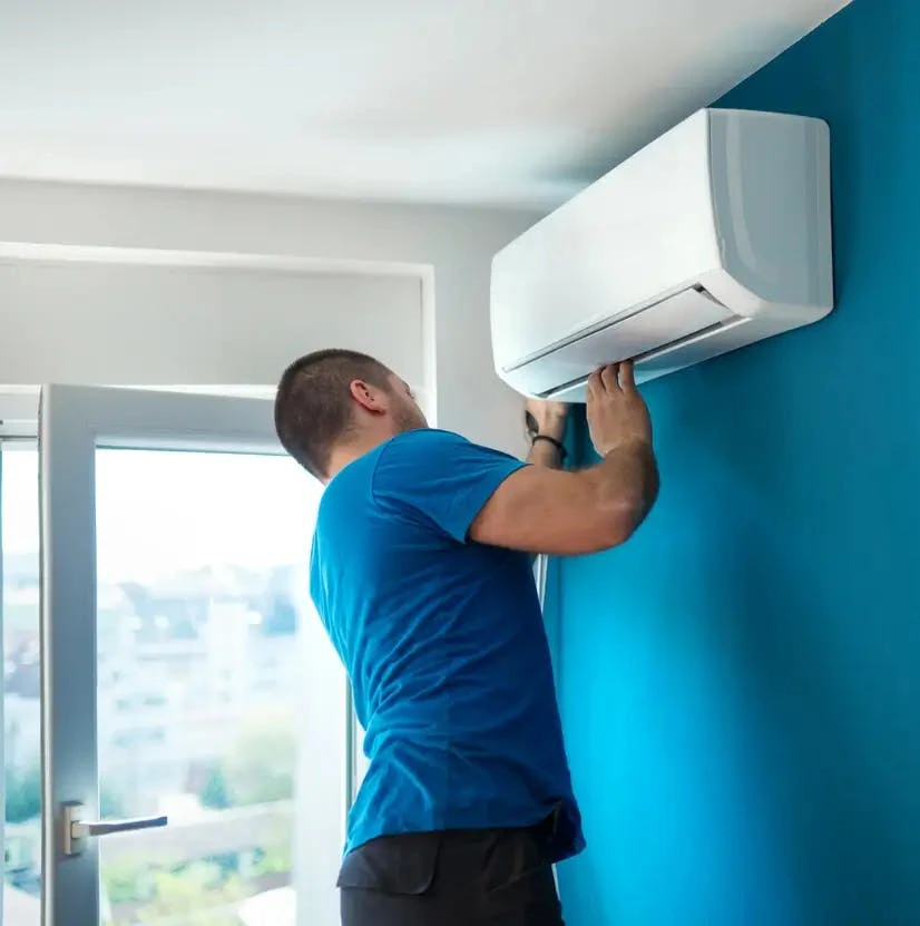 Technicien installant une climatisation murale bleue
