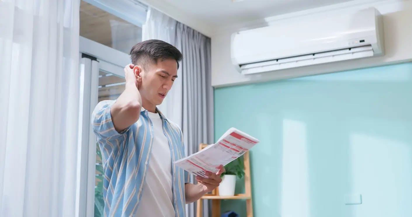 Homme lisant une notice de climatiseur dans un salon