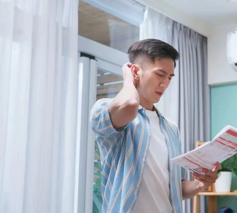 Homme lisant une notice de climatiseur dans un salon