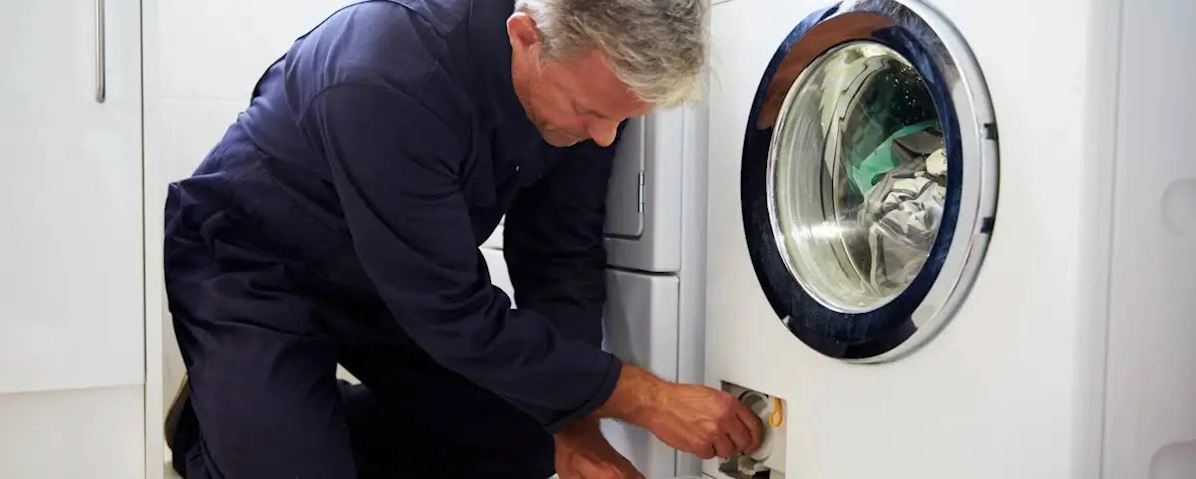 Technicien entretenant un sèche-linge pour faire des économies