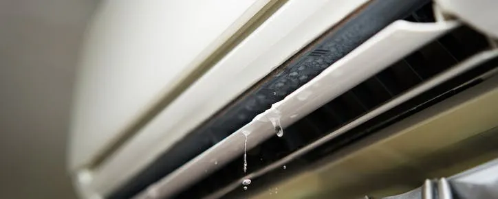 Climatiseur mural qui fuit avec des gouttes d'eau visibles