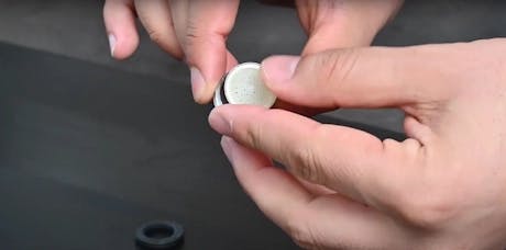 Mains inspectant un joint en caoutchouc blanc pour robinet