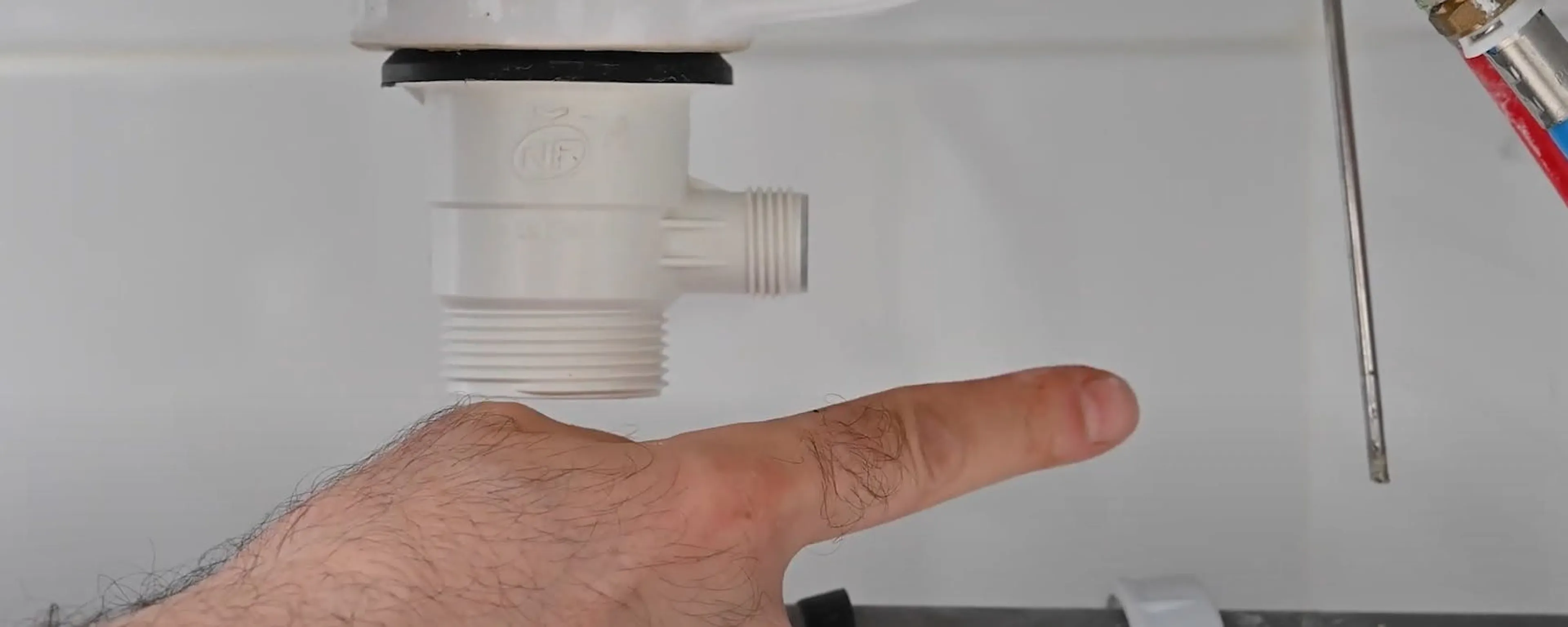 Main montrant une bonde de lavabo encrassée