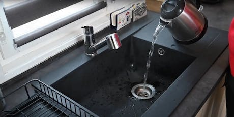 Évier de cuisine noir avec bouilloire versant de l'eau