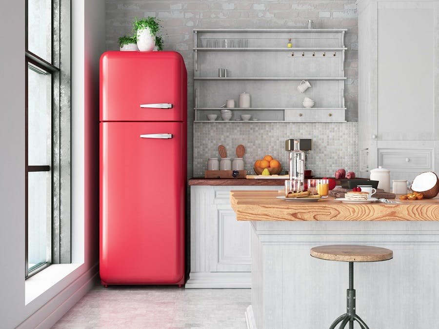 Réfrigérateur rouge vintage dans une cuisine moderne blanche