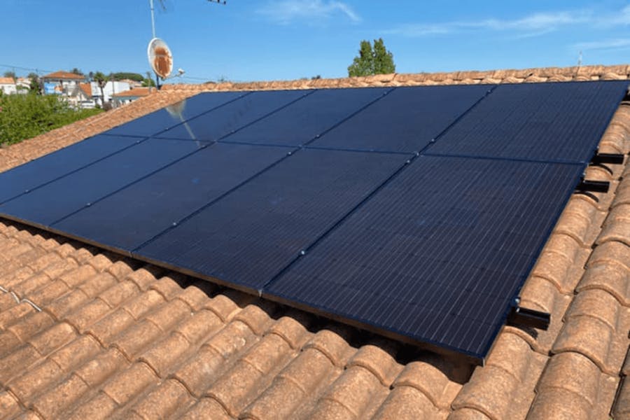 Panneaux solaires noirs installés sur un toit en tuiles
