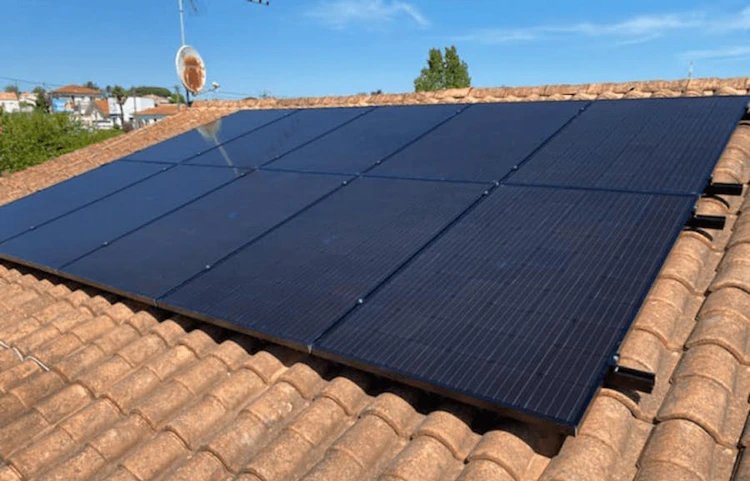 Panneaux solaires noirs installés sur un toit en tuiles