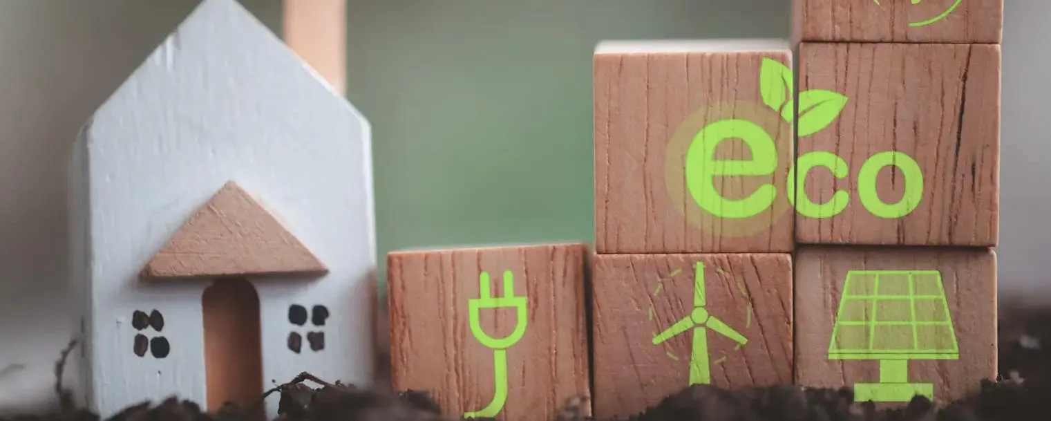 Cubes en bois avec icônes écologiques et maison miniature sur terre symbolisant une maison préparée au changement climatique