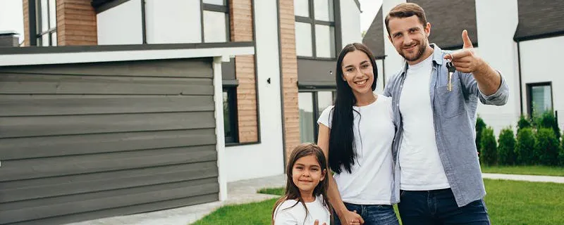 Famille souriante devant leur maison bien préparée avant le départ en vacances