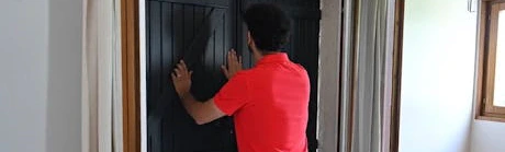 Homme vérifiant la fermeture d'une porte avant de partir en vacances