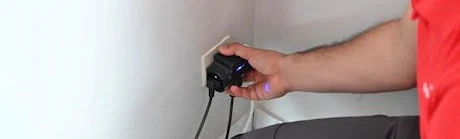 Personne débranchant des appareils électriques d'une prise murale