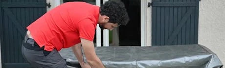 Personne recouvrant le mobilier de jardin avec une housse de protection