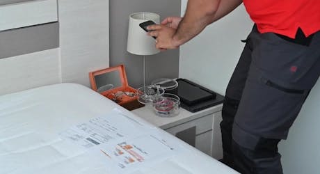 Technicien photographiant des objets de valeur sur une table de chevet