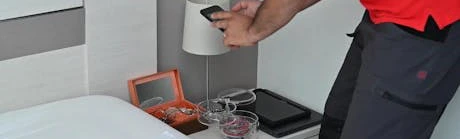 Technicien photographiant des objets de valeur sur une table de chevet