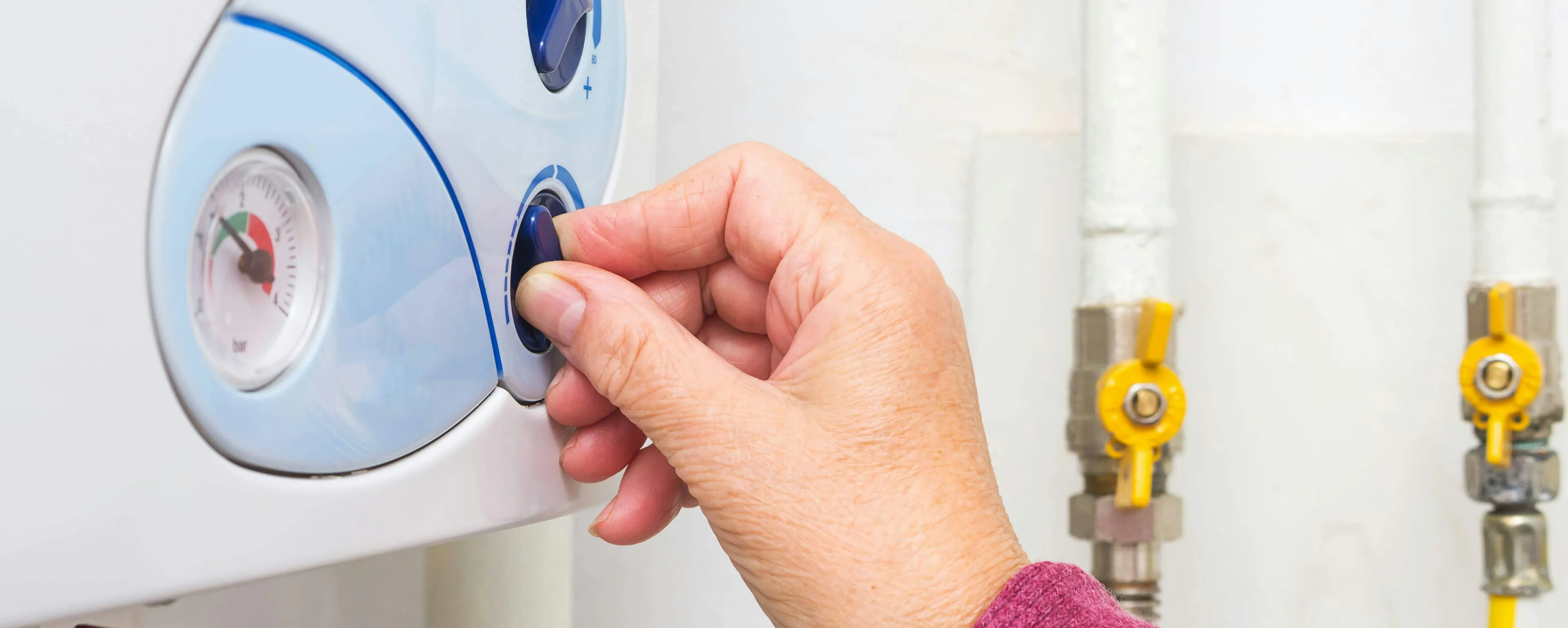 Main éteignant une chaudière gaz murale blanc afin de la purger