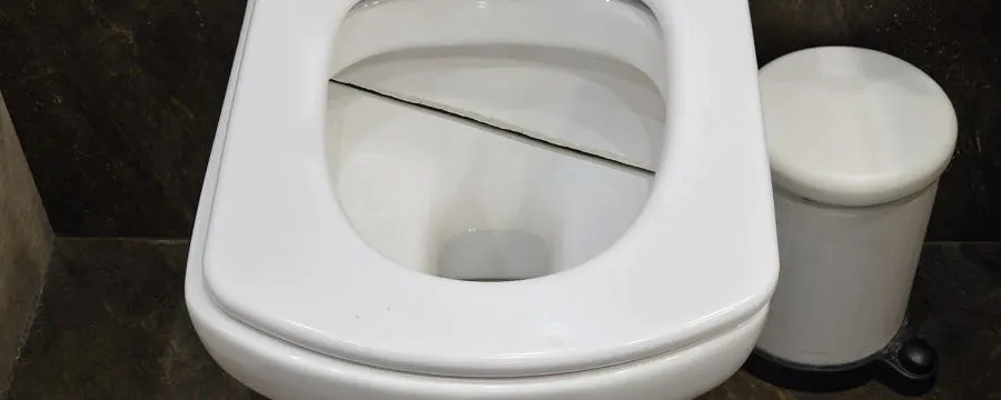 Cuvette de WC blanche fendue vue de dessus dans une salle de bain