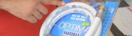 Main tenant un flexible de gaz renforcé Optima dans son emballage