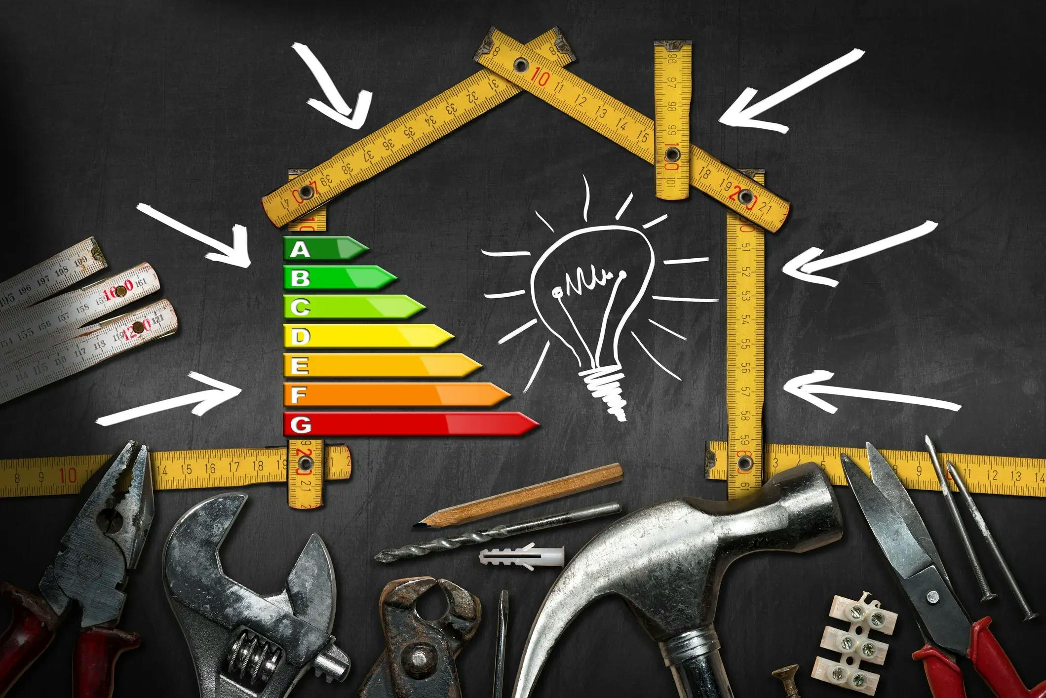 Maison en mètre pliant avec étiquette de performance énergétique DPE de A à G et ampoule dessinée, entourée d'outils de bricolage