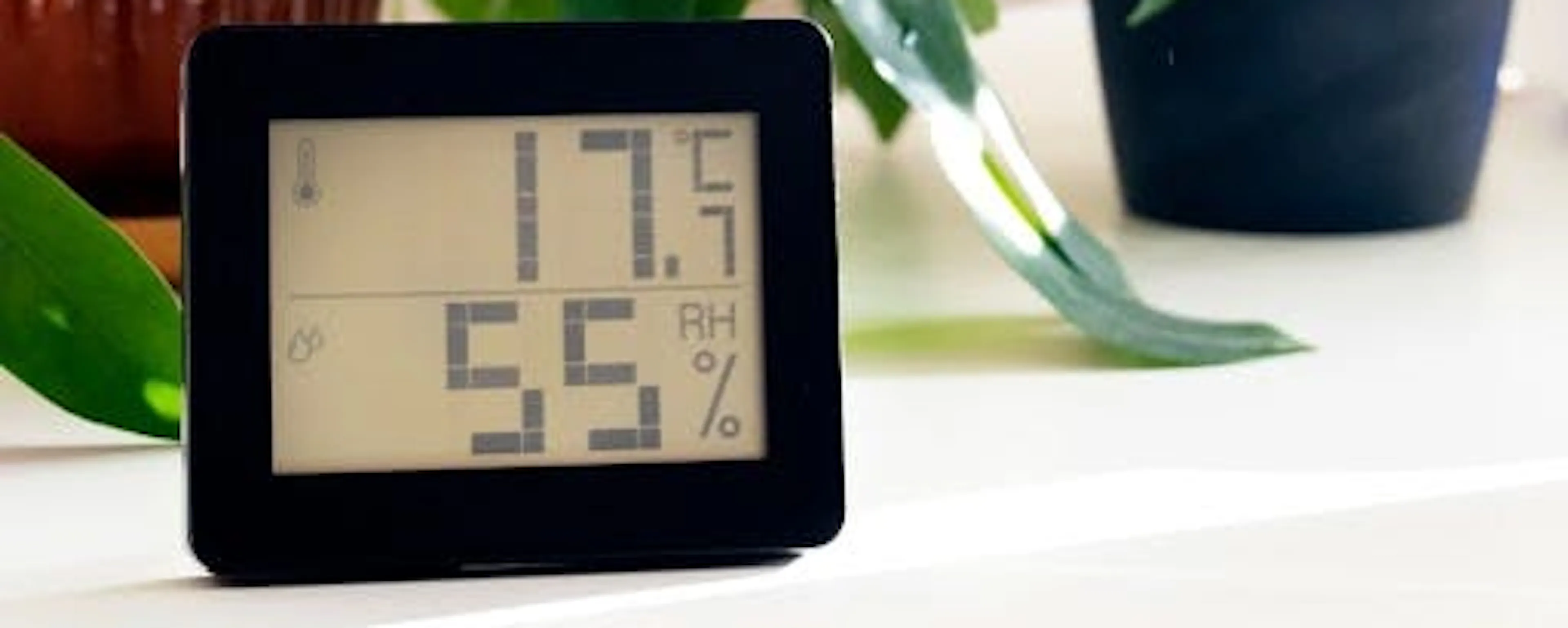 Hygromètre numérique affichant 55% d'humidité mesurant le taux d'humidité idéal dans une maison