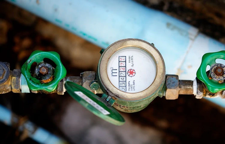 Compteur d'eau avec robinets verts sur tuyauterie bleue