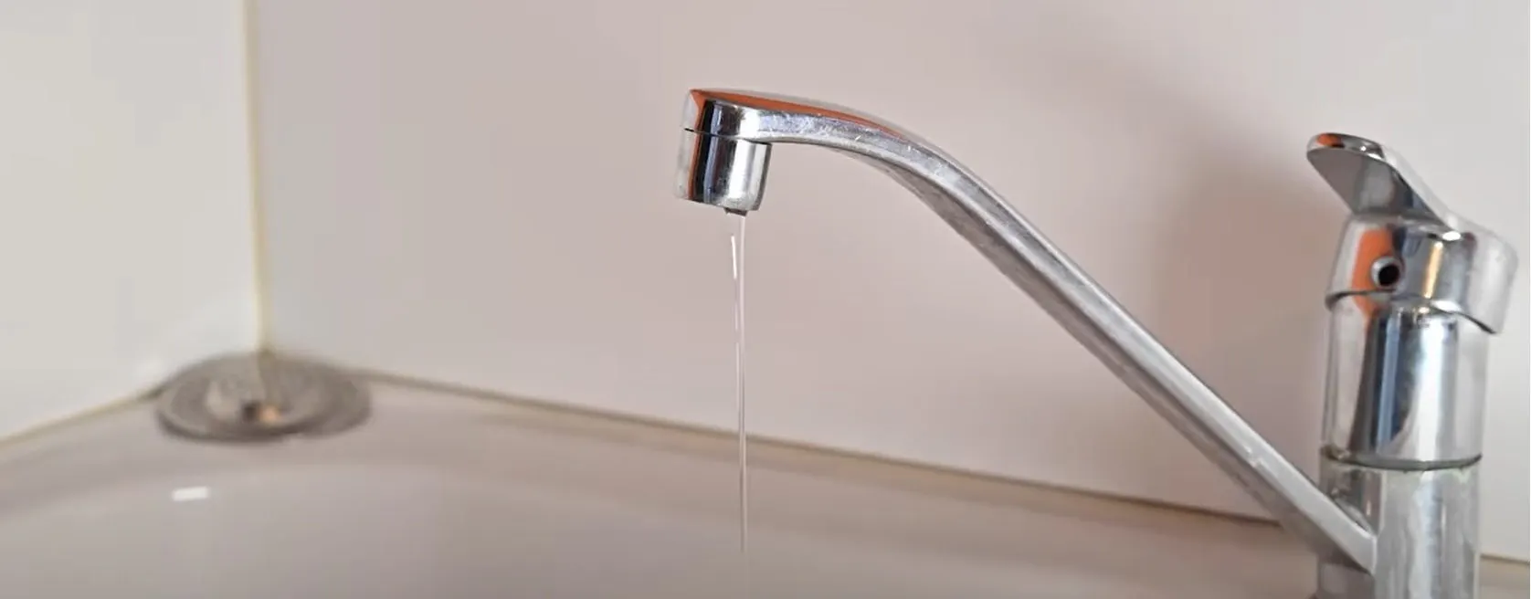 Robinet mitigeur chromé à changer de cuisine qui goutte au-dessus d'un évier